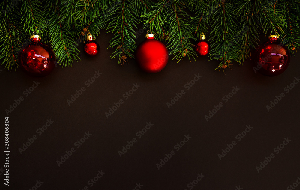 Christmas card concept with fir tree branches and red shiny balls on dark background - text space. Merry Christmas and Happy Holidays greeting card. Flat lay, top view. Copy space for your text. Christmas card concept with fir tree branches and red shiny balls on dark background - text space. Merry Christmas and Happy Holidays greeting card. Flat lay, top view. Copy space for your text.