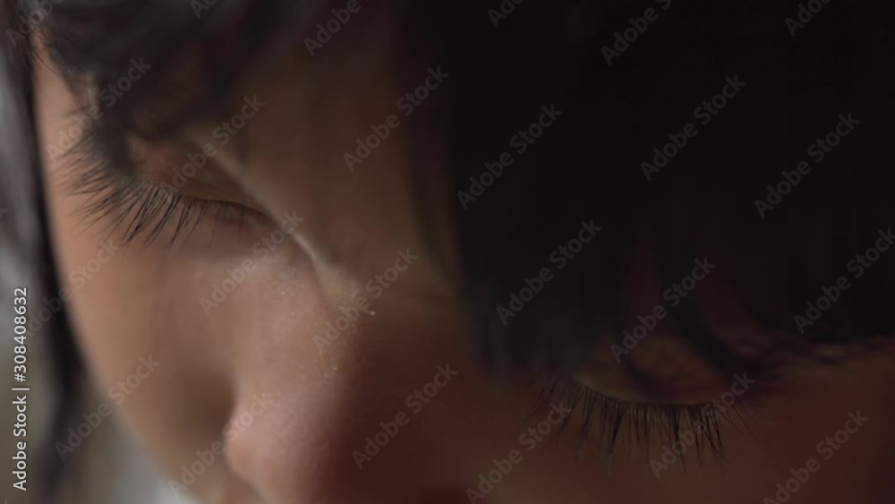 Extreme Close UP Macro Young Asian Girls eyes as she draws indoors alone isolated in dimly lit room Extreme Close UP Macro Young Asian Girls eyes as she draws indoors alone isolated in dimly lit room