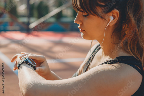 Close up portrait of a beautiful plus size woman looking at her port wathc in the mornign setting to monetize the pulse before doing losing weight exercises. photo