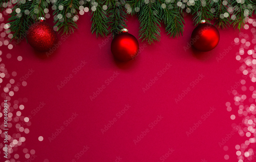 Christmas holidays composition on red background with copy space for your text. Christmas red decorations, fir tree branches on red background. Flat lay, top view, copy space.