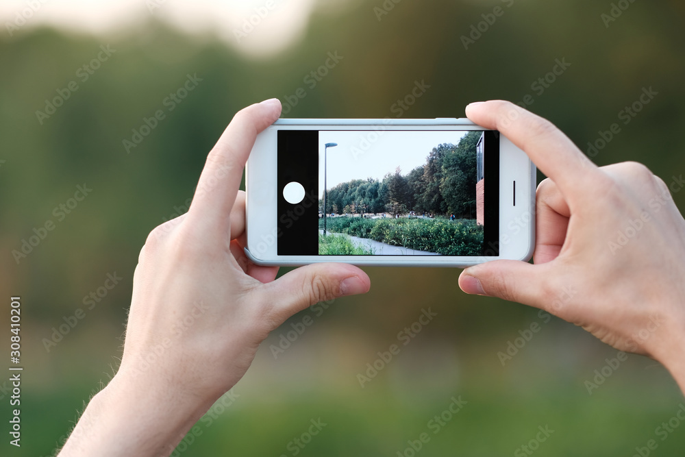 Hand taking photo with smartphone. Image of nature, park. Hand taking photo with smartphone. Image of nature, park.