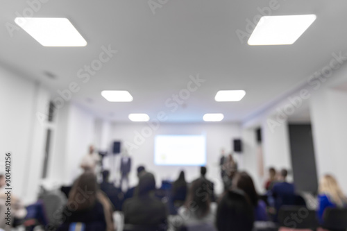unfocused bright co working space interior hall people silhouettes and symmetry roof lamps illumination