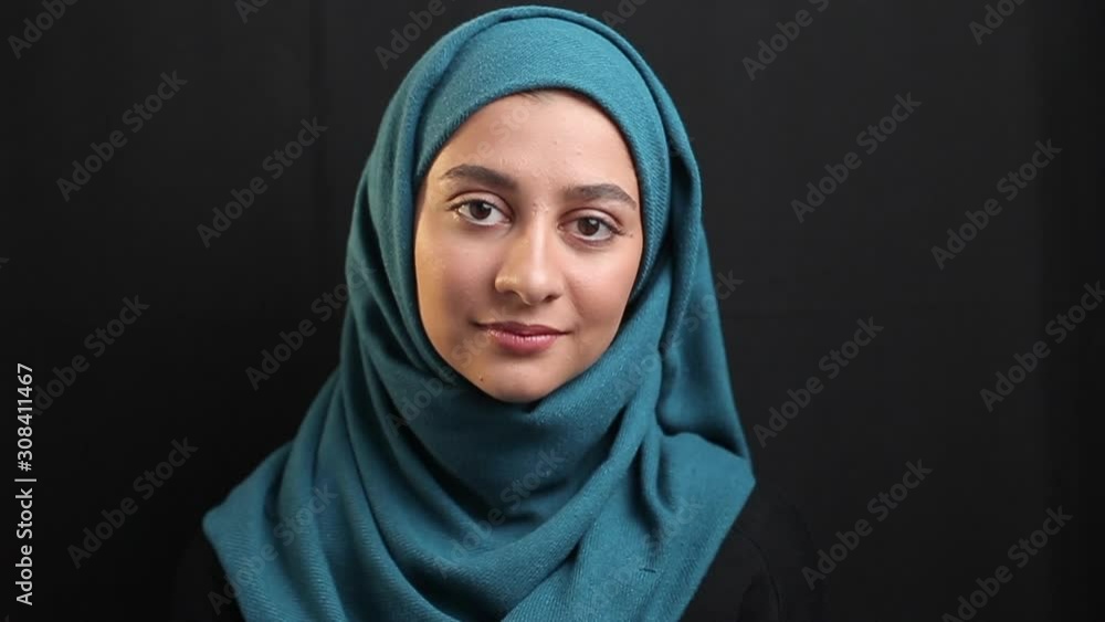 Closeup of a beautiful muslim girl in hijab. Portrait of an arab young woman on black background. Closeup of a beautiful muslim girl in hijab. Portrait of an arab young woman on black background.
