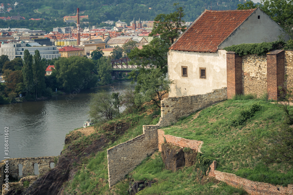 old house with a stone fence on the steep bank of the Vltava river in Prague