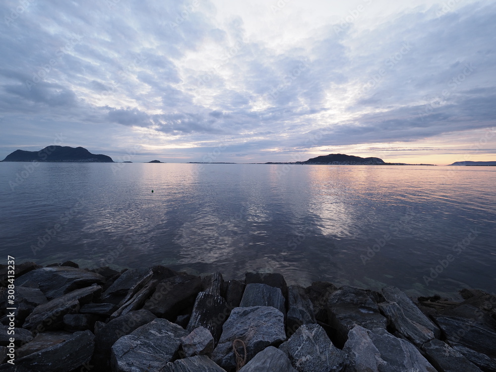 Rocky waterfront and landscape of bay seen from european Alesund town at Romsdal in Norway at blue hour