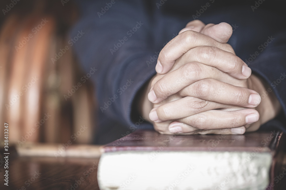 Young woman praying With the Holy Bible  in the morning, Woman praying with hands together.
