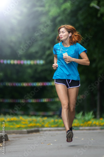 young asian woman with Red hair jogging in a city park