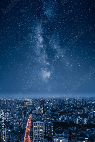 Fototapeta Naklejka Na Ścianę i Meble -  A city at night with an epic milky way on the sky