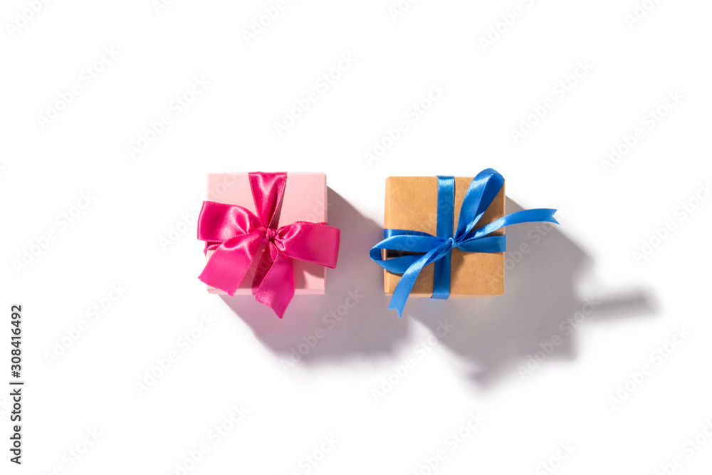 Two gifts, blue and pink gift on a white background. Natural light with a hard shadow. Holiday concept, gift. Flat lay, top view
