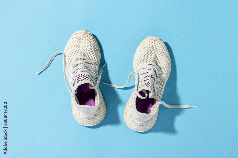 White sneakers under morning sunlight on a blue , running,  fitness, cross fit, hard workout. Morning run. Banner. Flat lay, top view  Stock Photo | Adobe Stock
