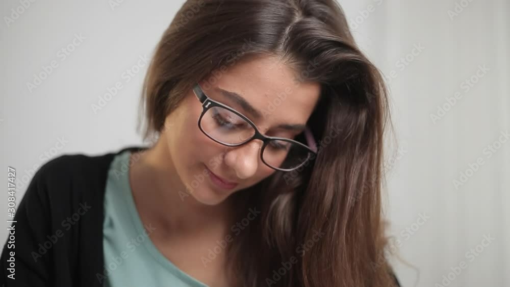 Portrait of a student girl who writes something in a notebook and smiles. Portrait of a student girl who writes something in a notebook and smiles.