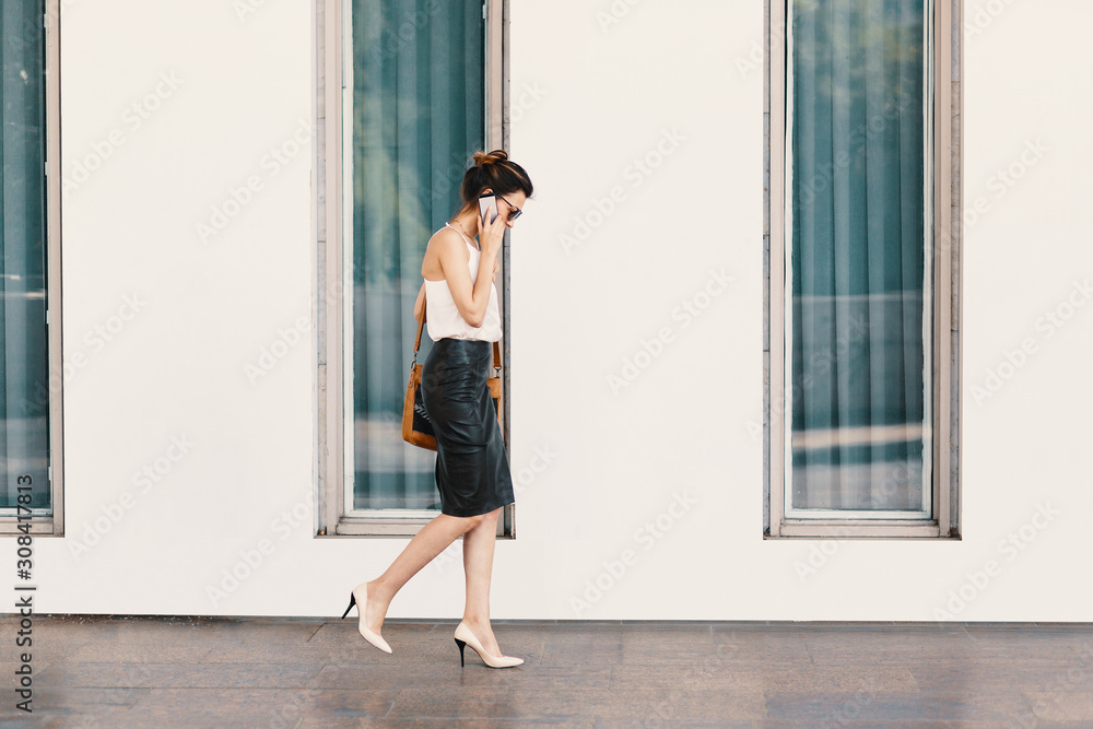 Business woman in leather skirt talking on the phone Business woman in leather skirt talking on the phone
