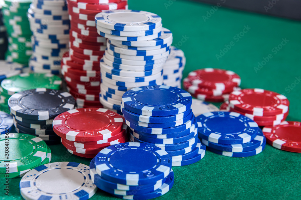 Colorful casino chips on green felt table close up. Gambling concept. Playing poker and other gambling games Colorful casino chips on green felt table close up. Gambling concept. Playing poker and other gambling games