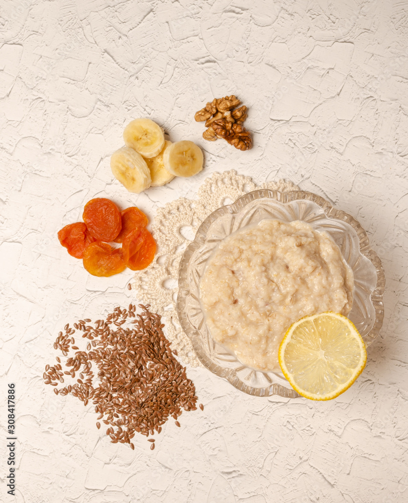 Oatmeal in plate, milk, dried fruits, a spoon on the table and napkins. Healthy breakfast. Oatmeal in plate, milk, dried fruits, a spoon on the table and napkins. Healthy breakfast.