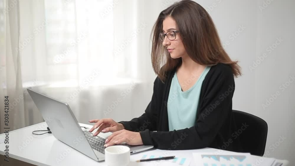 Indian business woman working on laptop with financial charts in a modern office. Indian business woman working on laptop with financial charts in a modern office.