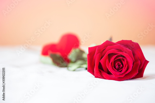 Red rose on white sheet with blrred red heart on the background, vintage filter effect, love and romance, valentine background photo