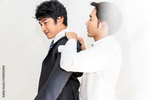 Asian homosexual couple helping each other dress up.Concept LGBT gay.