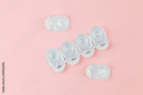 Contact lens packages a pink background. Stack of healthcare disposable contact lens. Flat lay composition