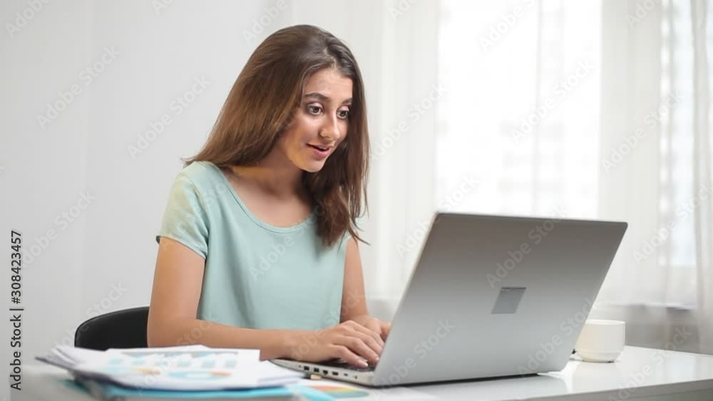 Indian young woman shocked and surprised looking at laptop monitor. Indian young woman shocked and surprised looking at laptop monitor.