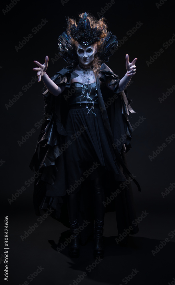 Portrait of woman witch in black clothes conjures on the dark background Portrait of woman witch in black clothes conjures on the dark background