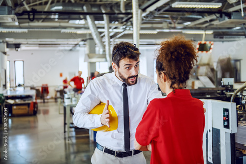 Obraz na płótnie Angry caucasian bearded director in shirt and tie arguing with his sloppy female employee