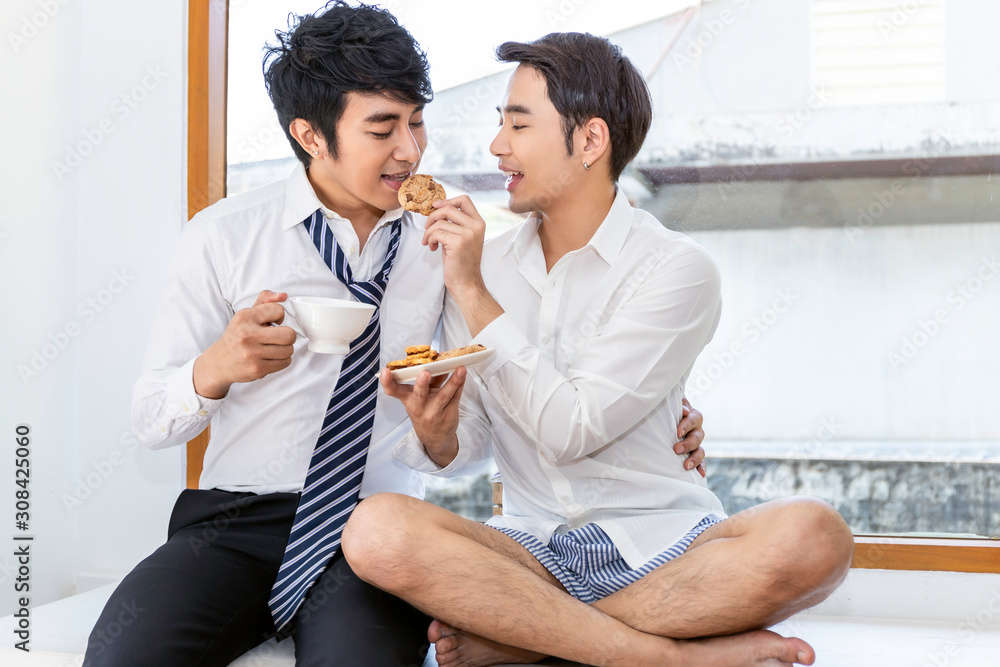 Relax and tea time.Portrait of Asian homosexual couple eating cookie and enjoy funny moment.Concept LGBT gay. Relax and tea time.Portrait of Asian homosexual couple eating cookie and enjoy funny moment.Concept LGBT gay.