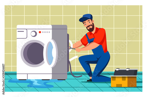 Plumber repairing washing machine in bathroom