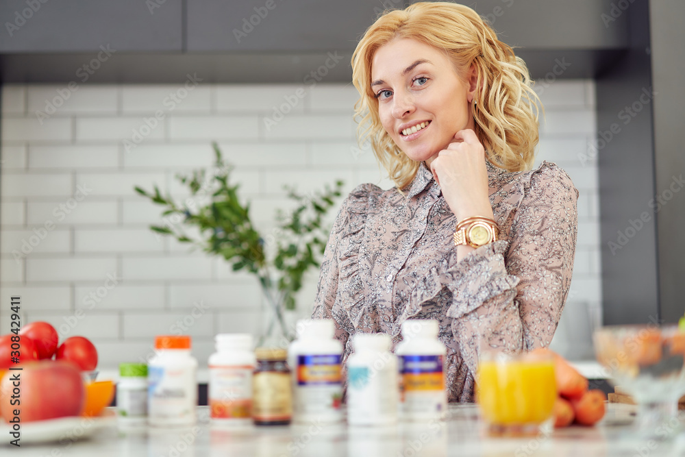 female nutritionist talks about vitamin on a table at home with vegetarian food female nutritionist talks about vitamin on a table at home with vegetarian food