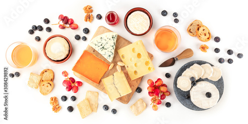 Cheese board panorama with wine and fruit, a flat lay, shot from the top on a white background