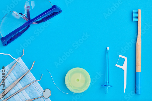 Dentist tools over blue background top view flat lay. Tooth care  dental hygiene and health concept.