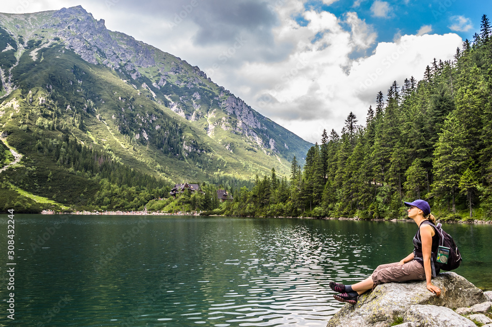 Woman tourist with backpack at Morskie Oko lake near Zakopane, Tatra Mountains, Poland