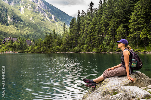 Woman hiker with backpack at Morskie Oko lake near Zakopane, Tatra Mountains, Poland