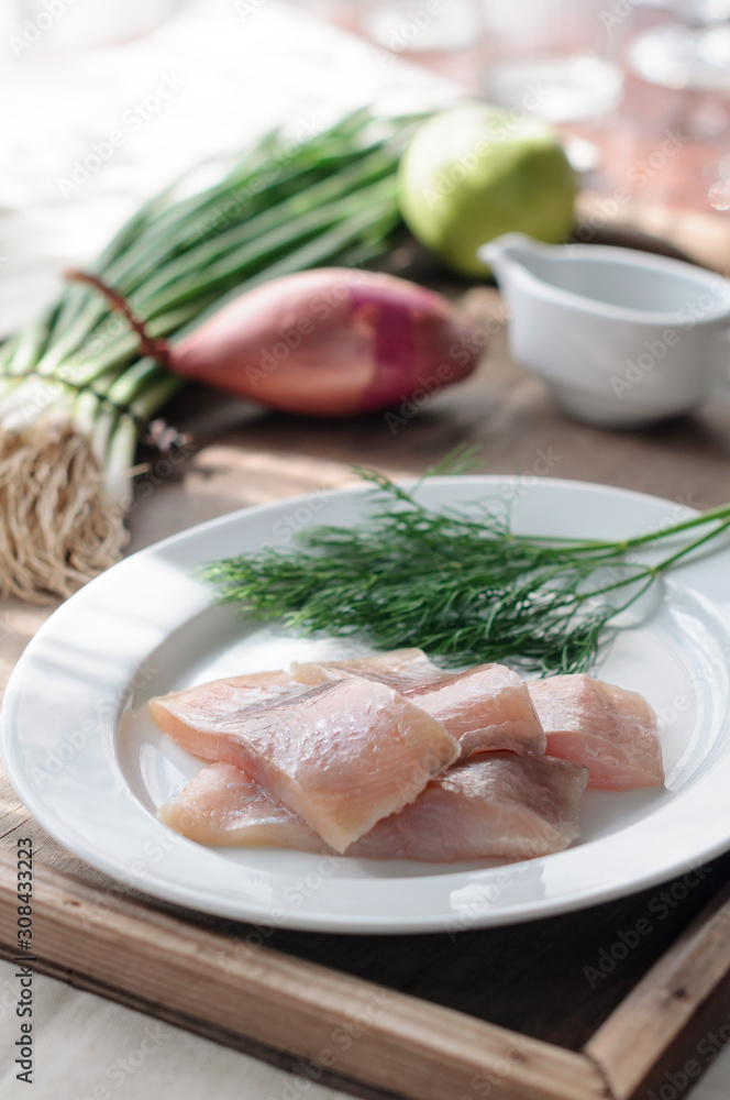 Sliced Herring Fish Fillet on White Plate. Dill and Onion Sliced Herring Fish Fillet on White Plate. Dill and Onion
