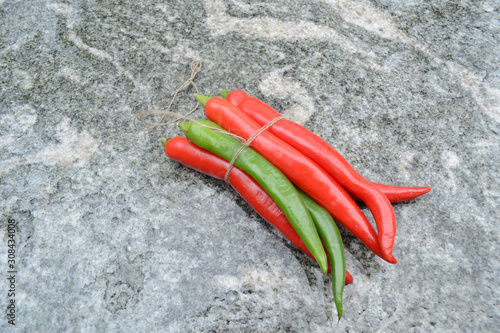Rote und grüne Peperoncini auf Granittisch