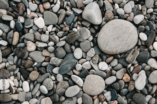 Gravel pattern of wet colored stones. Abstract nature pebbles background. Stone background. Sea peblles beach. Top view
