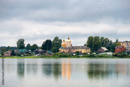 View of the Trinity Church and residential buildings on Kirov street across Lake Bologoe. City Bologoe, Tver region, Russia