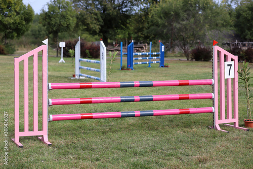 Colorful barriers on the ground for jumping horses and riders at riding school as a background.Obstacles for horses in a riding school