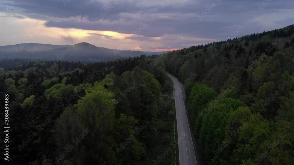 Aerial Drone View: Flight in the mountains over pine tree forest and road in sunset soft light. Nature, travel, holidays. Carpathians, Ukraine, Europe. Aerial Drone View: Flight in the mountains over pine tree forest and road in sunset soft light. Nature, travel, holidays. Carpathians, Ukraine, Europe.