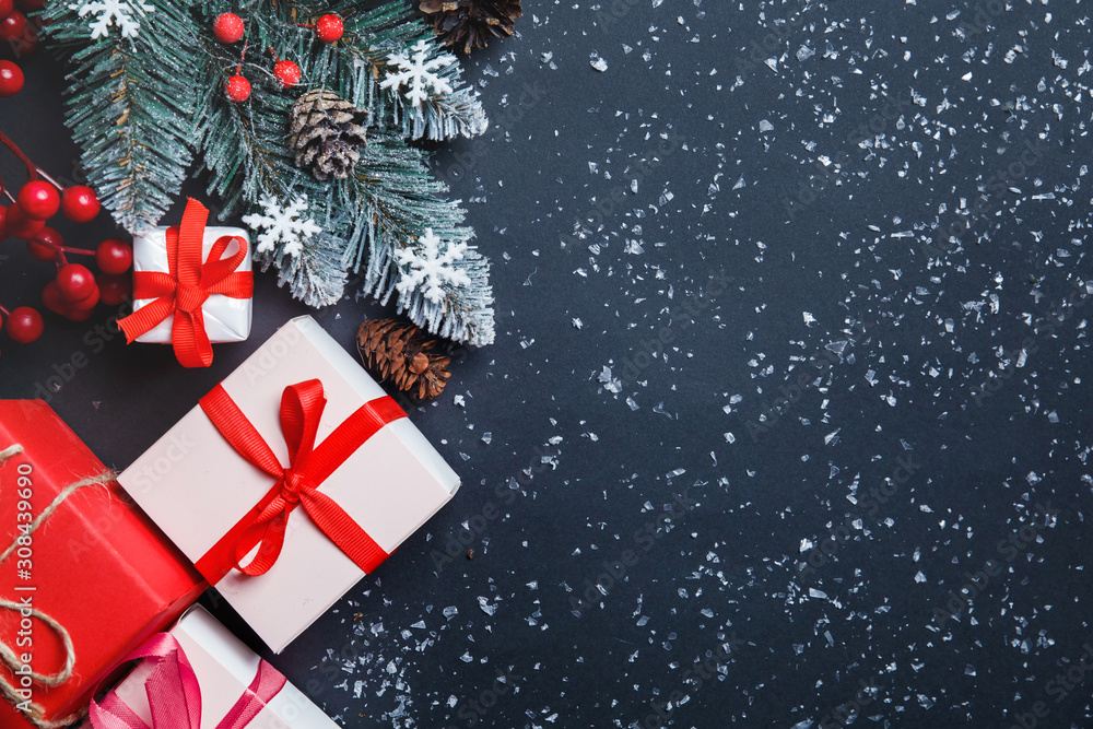 Christmas background with fir tree, Christmas present boxes, snowy fir branches, conifer cones, gift on a dark background. Top view. Copy space. New Year. Decoration Christmas background with fir tree, Christmas present boxes, snowy fir branches, conifer cones, gift on a dark background. Top view. Copy space. New Year. Decoration