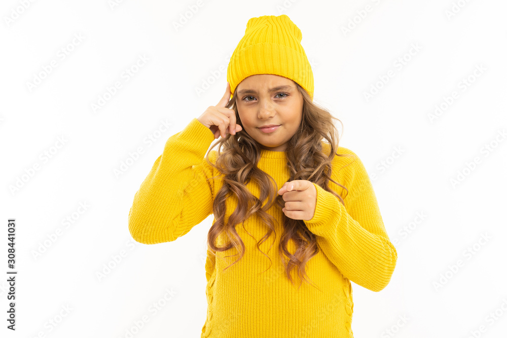 European attractive girl in a yellow hat twists at the temple on a white background European attractive girl in a yellow hat twists at the temple on a white background