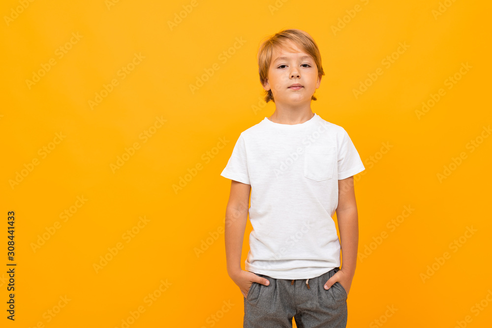 european boy in a white t-shirt with mockup on an orange background with copy space european boy in a white t-shirt with mockup on an orange background with copy space