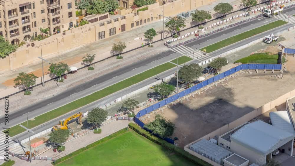 Excavator, truck and grader working at road construction site in Dubai downtown timelapse. Aerial view from above Excavator, truck and grader working at road construction site in Dubai downtown timelapse. Aerial view from above