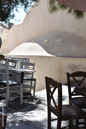 Greece, the island of Ios. The square in the village.  Tables and chairs by an old chapel. The cenre of lively nightlife in the evening, but in the Greek siesta it is quiet and peaceful. photo