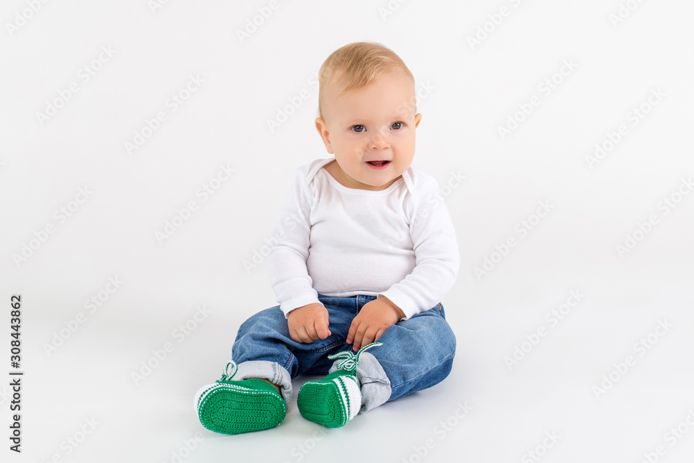 Cute kid sitting on the floor on the white background Cute kid sitting on the floor on the white background