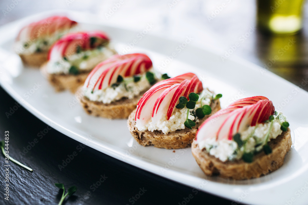 Canapes with cheese and garlic and radish, sprinkled with sprouts of young beans. Snack at the restaurant for alcohol Canapes with cheese and garlic and radish, sprinkled with sprouts of young beans. Snack at the restaurant for alcohol
