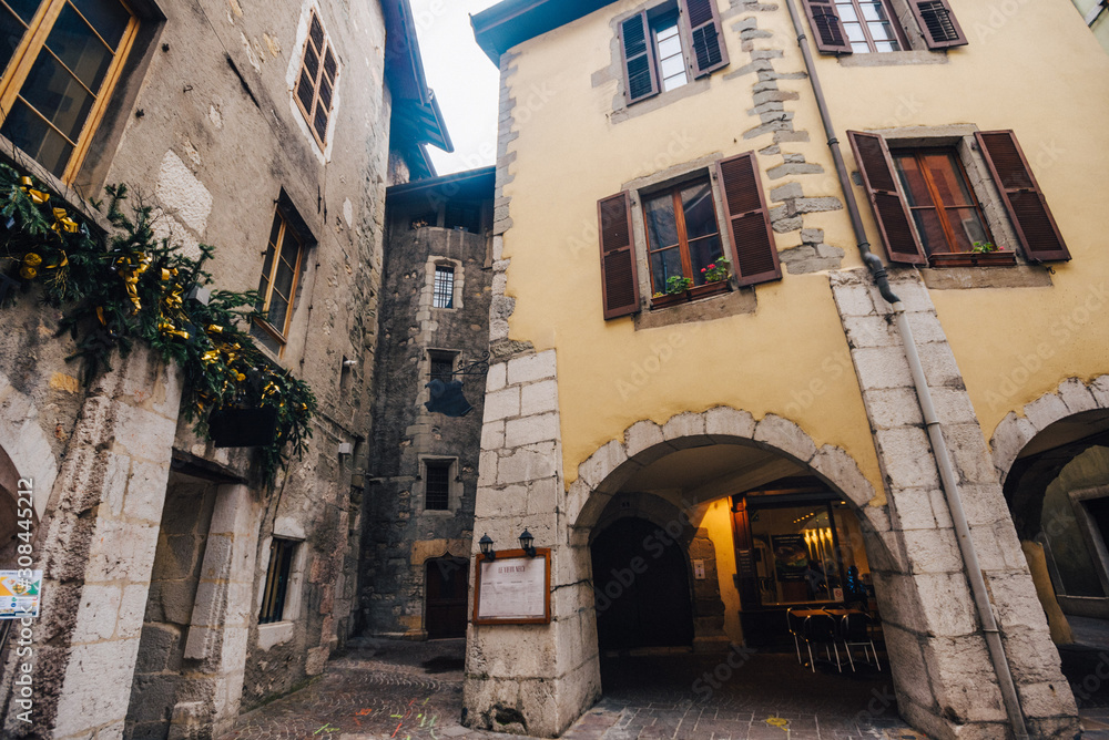 Medieval buildings at the center of old Annecy, France. Photography of a small European courtyard from old buildings of various architectural styles with an arch on the ground floor.