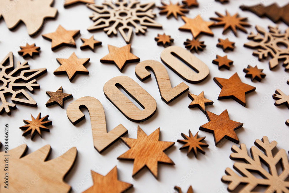 The beautiful christmas background with a lot of small wooden decorations and wooden numbers 2020 on the white desk. The beautiful christmas background with a lot of small wooden decorations and wooden numbers 2020 on the white desk.