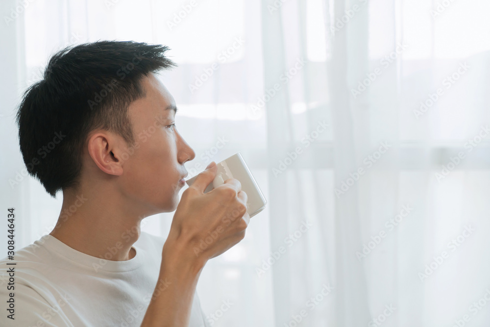 happy attractive man drinking in the morning in bedroom happy attractive man drinking in the morning in bedroom