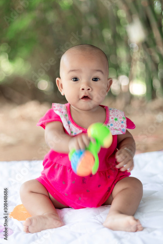 Cute little Asian baby sitting and play with happiness