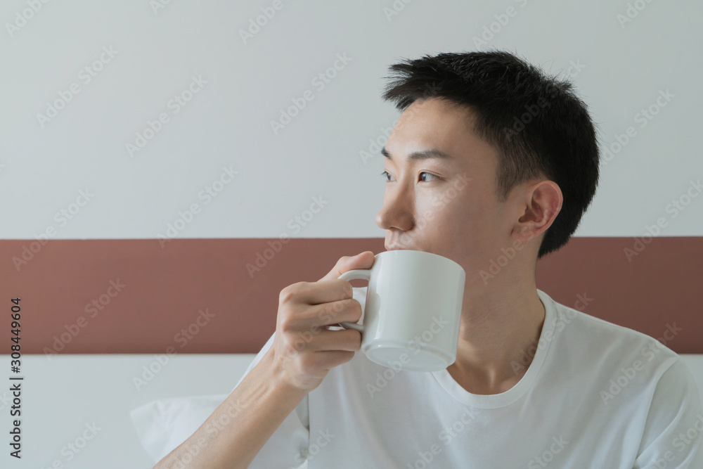 happy attractive man drinking in the morning in bedroom happy attractive man drinking in the morning in bedroom